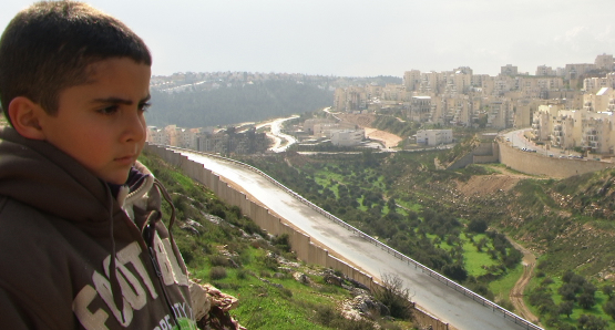 Emad's son Gibreel looks over at the Israeli settlements. 