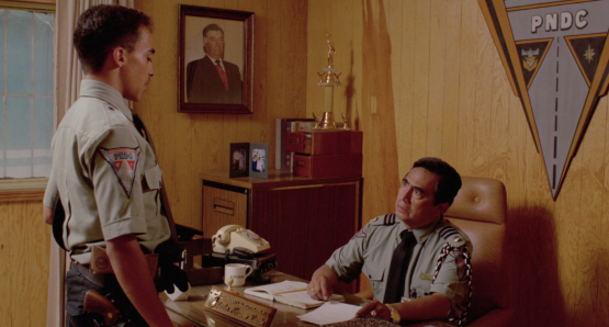 Comandante Navarro (Ernesto Gómez Cruz) reprimands rookie patrolman Pedro (Roberto Sosa) in Alex Cox's HIGHWAY PATROLMAN.