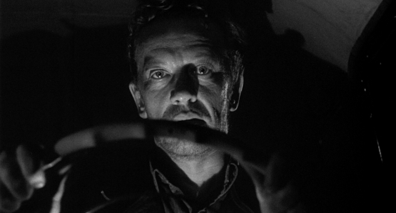 William Talman, as the titular character, takes the wheel in Ida Lupino's THE HITCH-HIKER.